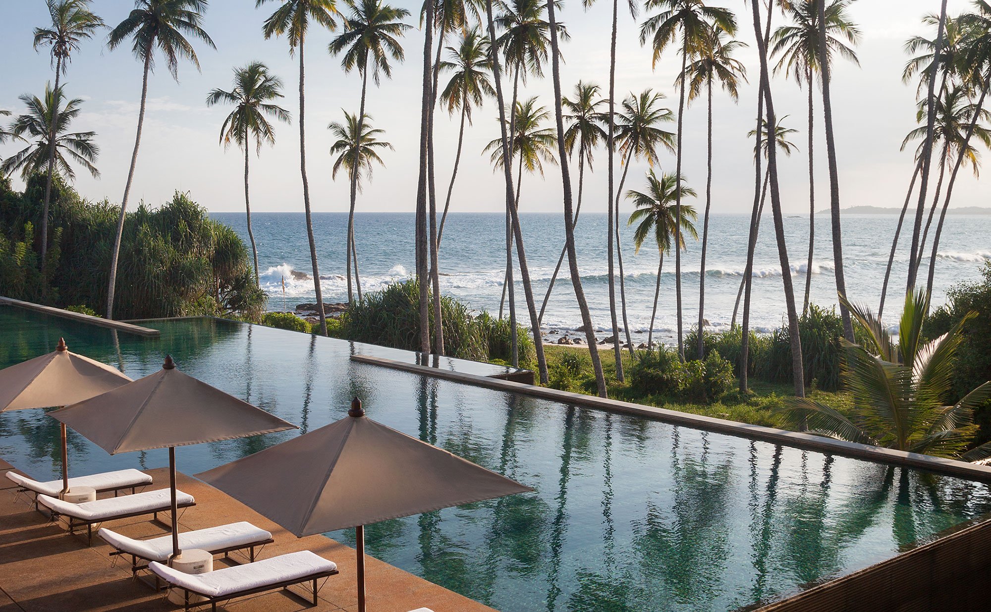 Amanwella, Sri Lanka udsigt fra poolen med palmer og bølger på havet