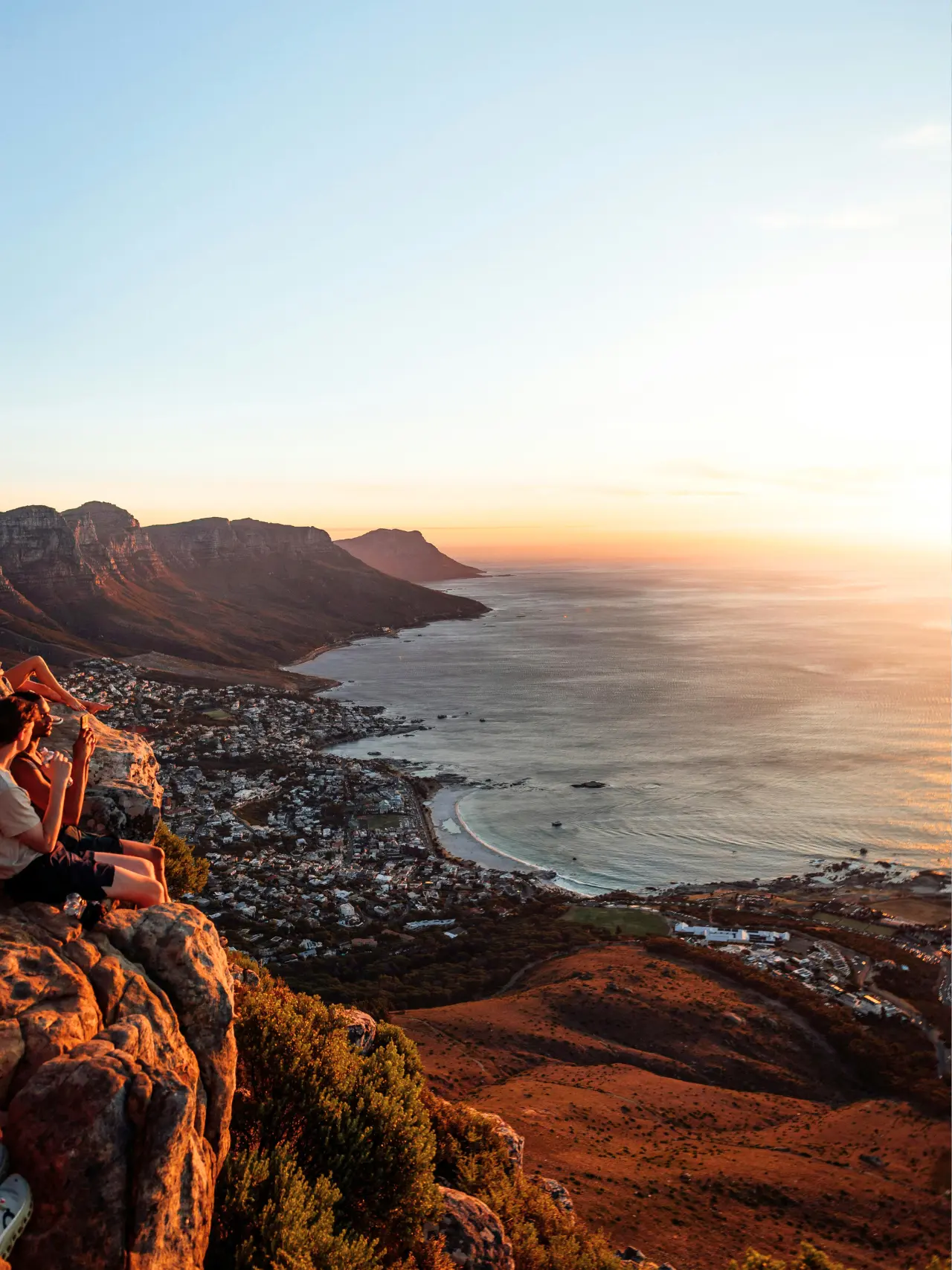 Unge kigger på solnedgang fra klipper i Cape Town, Sydafrika