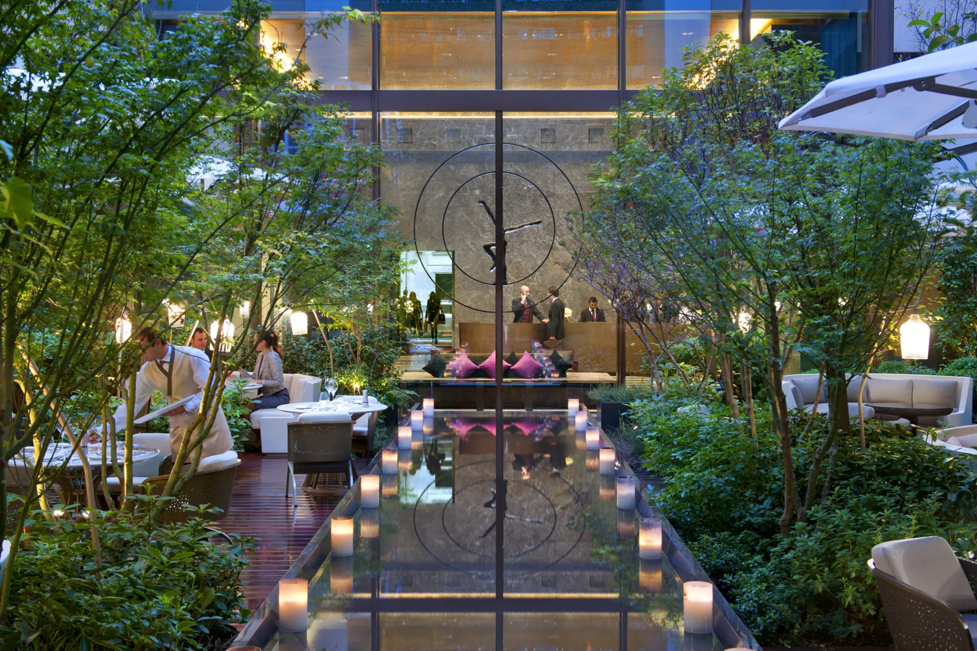 Restaurant med borde i grøn gårdhave på Mandarin Oriental Paris, Frankrig