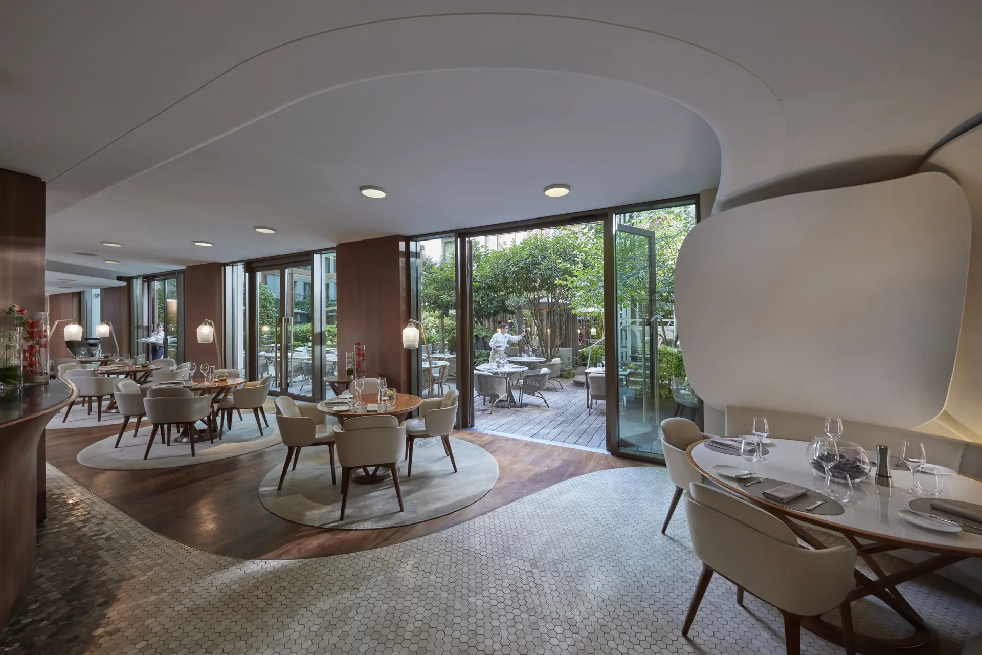 Restaurant med borde i grøn gårdhave på Mandarin Oriental Paris, Frankrig