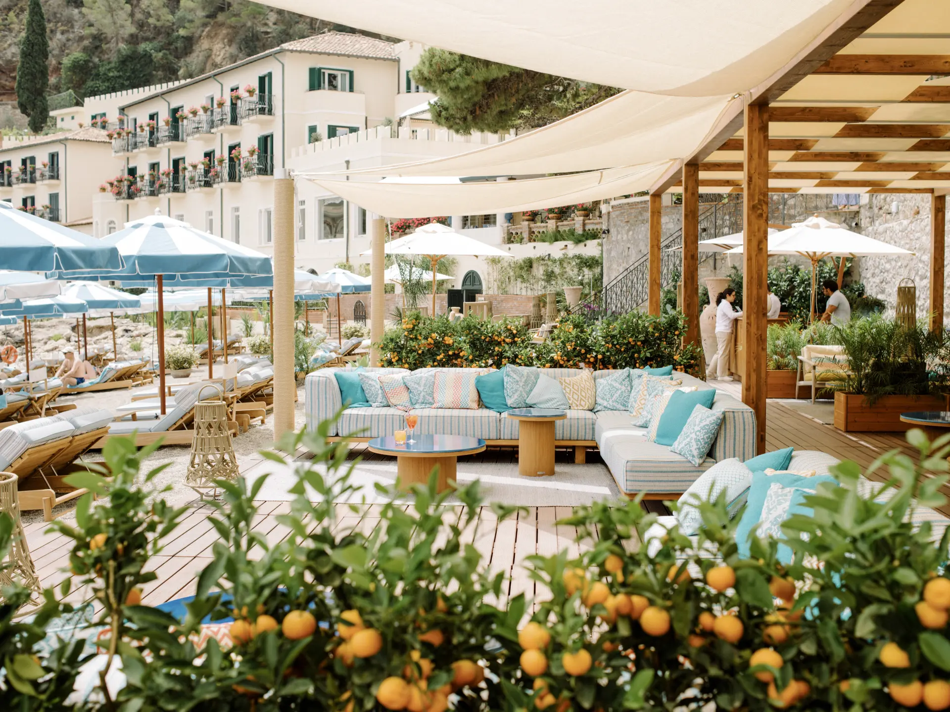 Strandlounge med drink, sofaer og solsenge ved baren på Villa Sant'Andrea, A Belmond Hotel, Italien