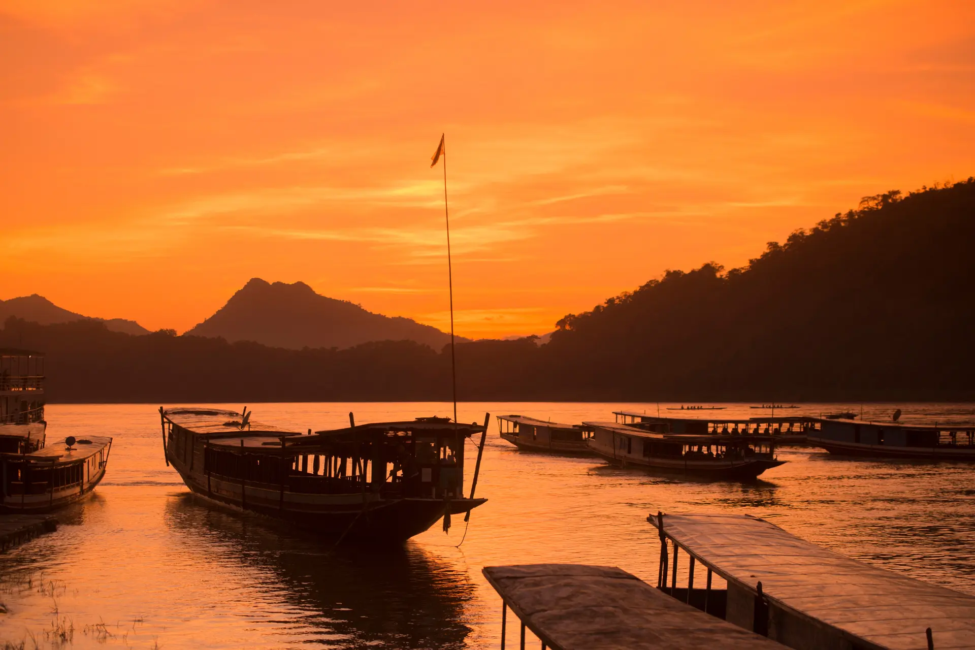 Solnedgang over både på Mekong-floden ved Luang Prabang i Laos