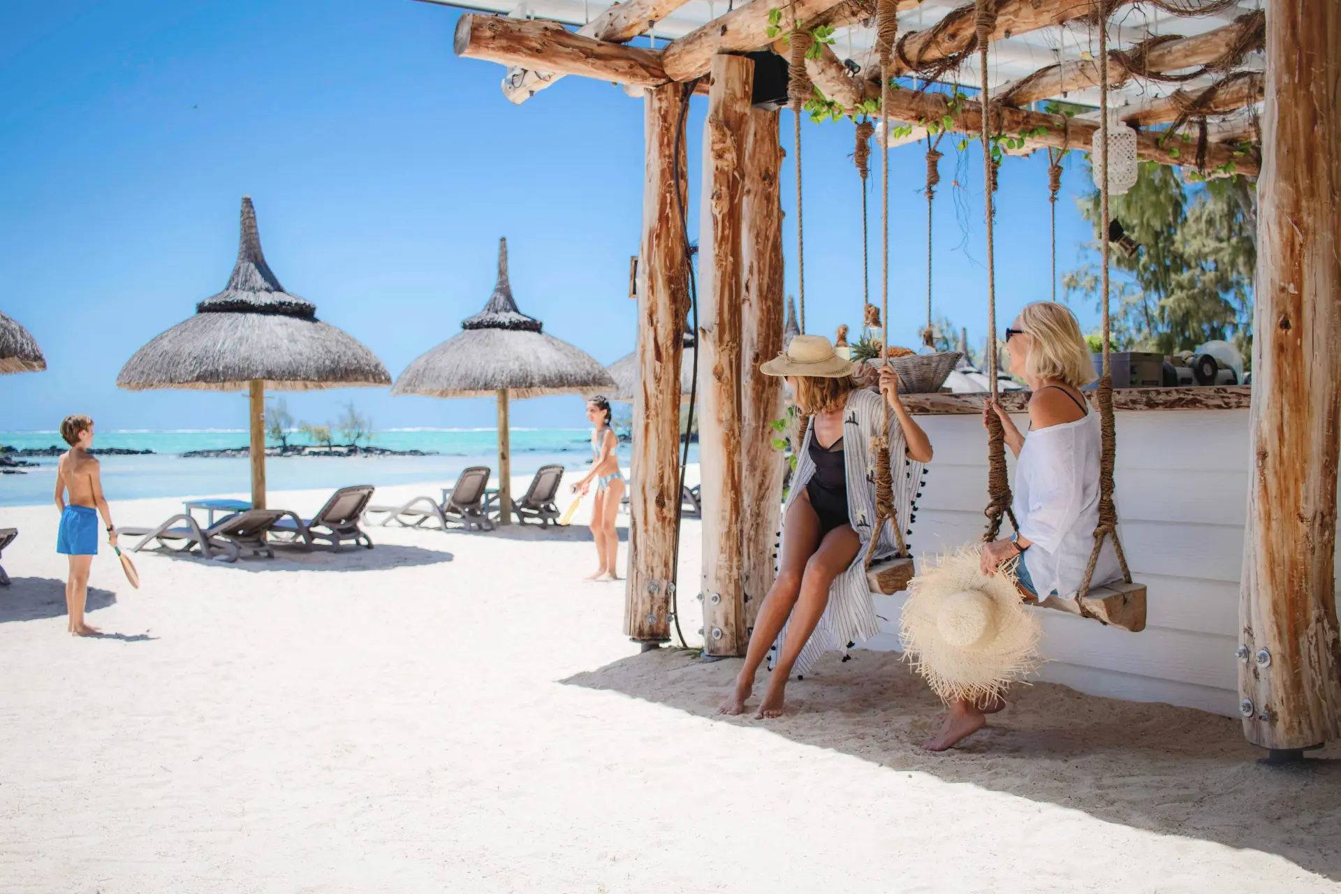 Kvinder og børn på strandbaren på Anahita Golf & Spa Resort, Mauritius