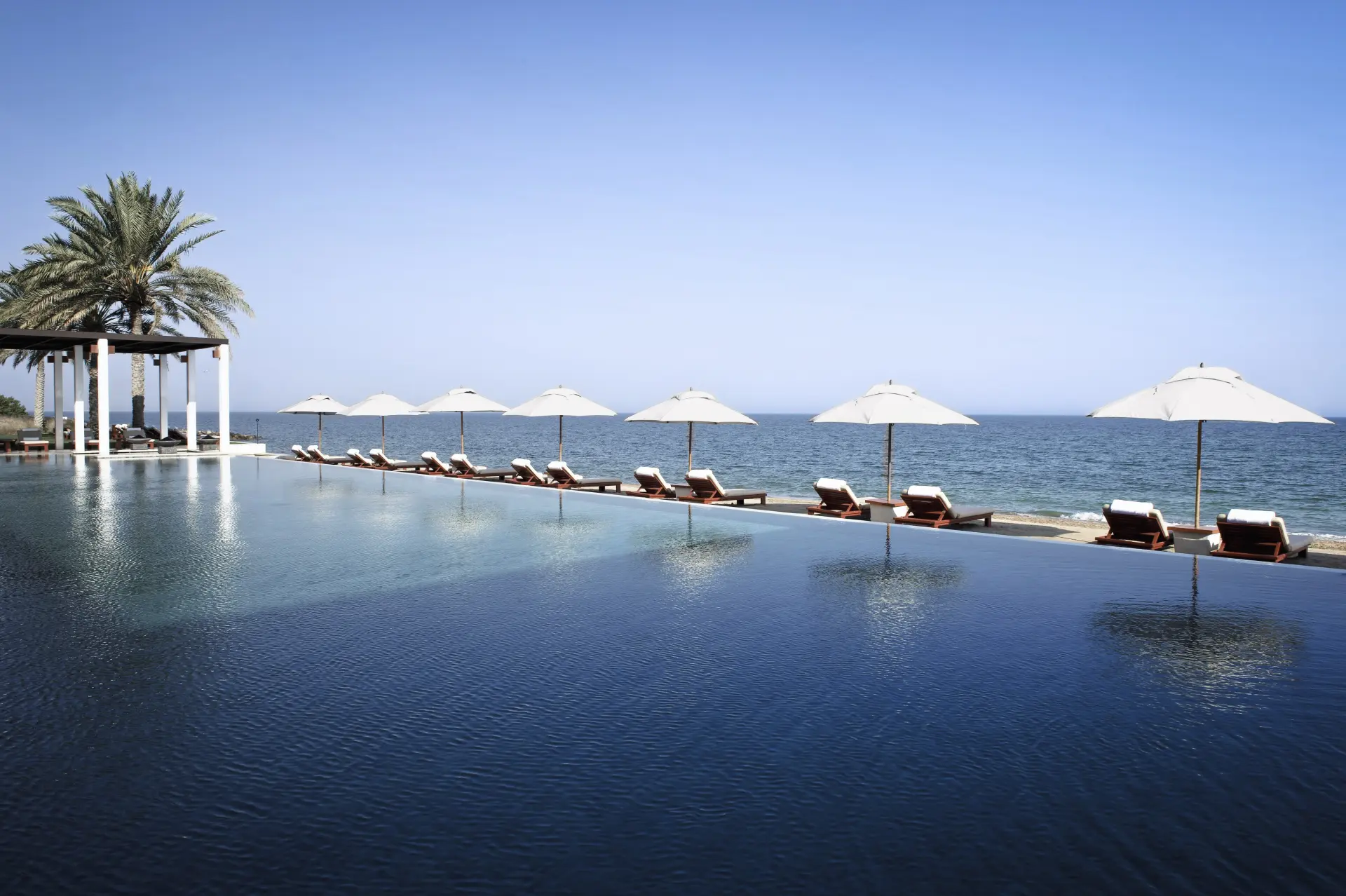 Infinitypool ved stranden på The Chedi Muscat, Oman