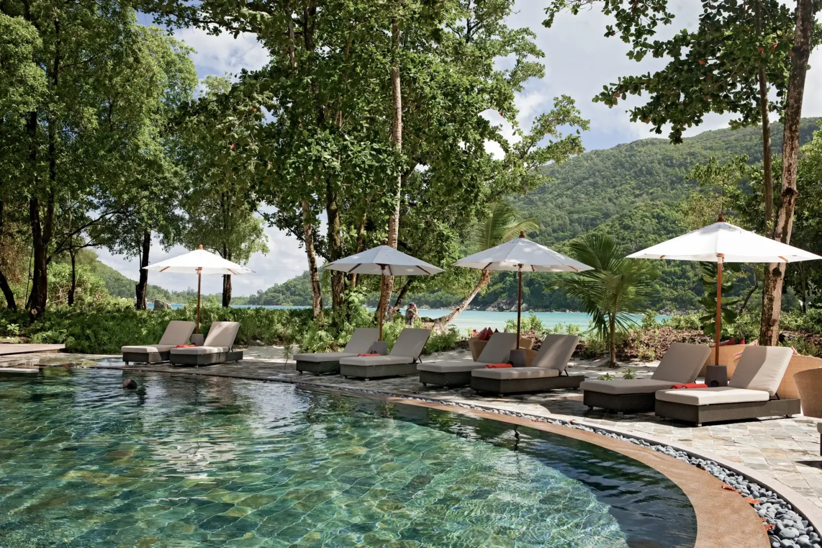 Solsenge med parasoller ved pool på Constance Ephelia, Seychellerne