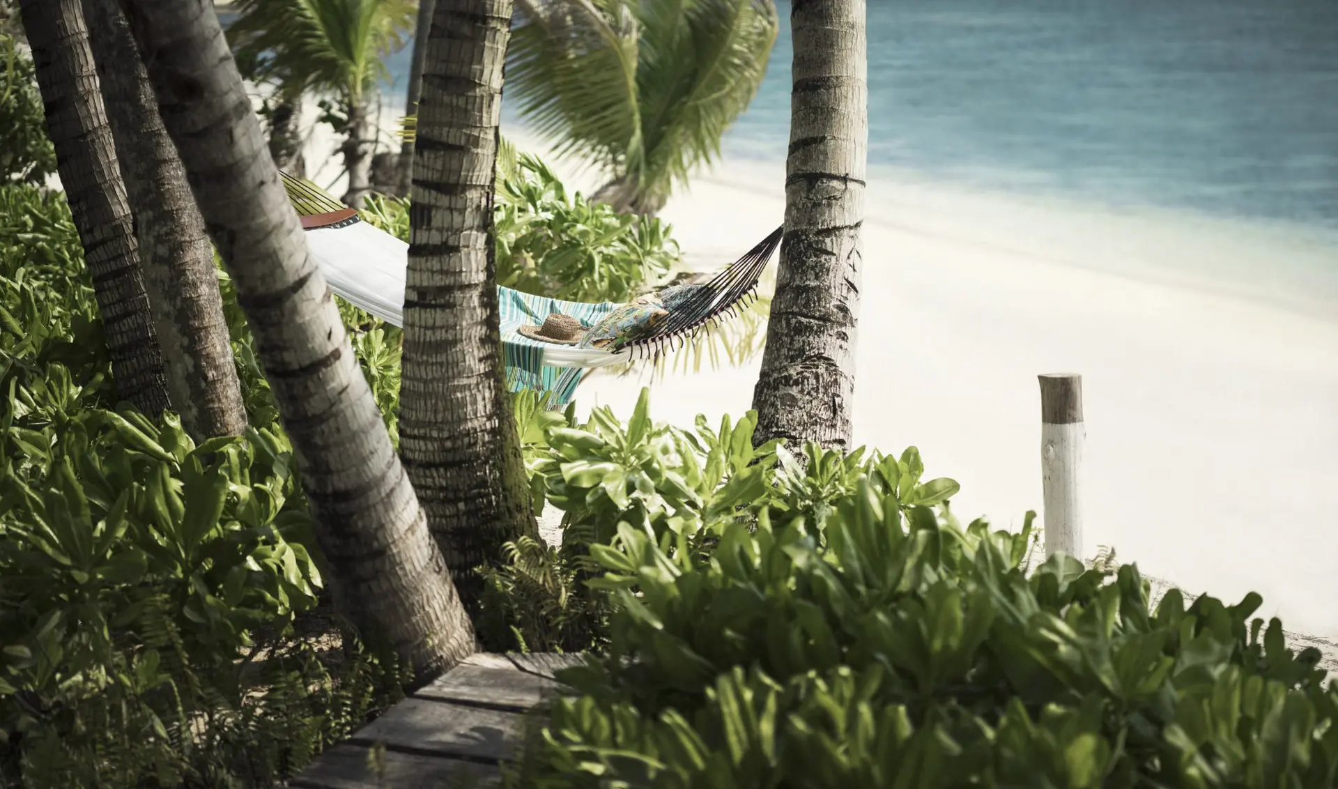 Hængekøje ved strandent på Four Seasons Resort at Desroches Island, Seychellerne