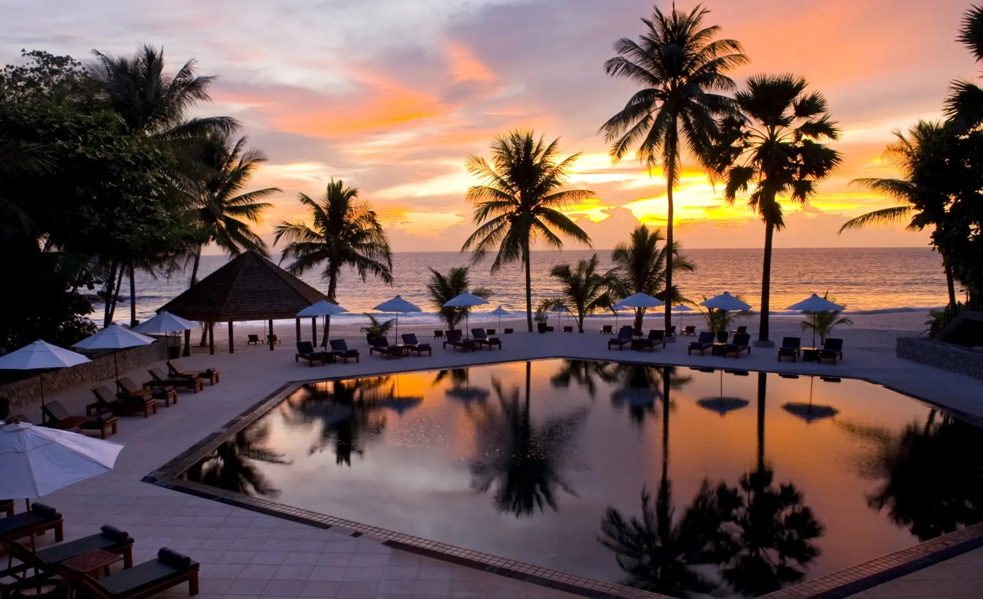 Main pool ved solnedgang på The Surin Phuket i Thailand